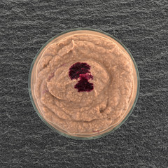 Yogurt berry smoothie in a crystal glass top view atop a black slate table.