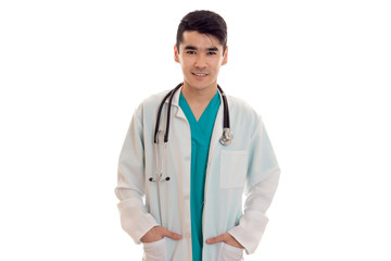 young handsome brunette man doctor in uniform with stethoscope on his shoulders looking and smiling on camera isolated on white background