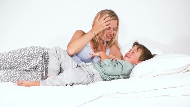 mutter und sohn kuscheln und spielen im bett