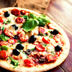 Delicious hot  pizza with salami, pepperoni and cheese on a dark background. Top view  Pizza circle  on  black table..