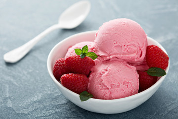 Raspberry ice cream in white bowl