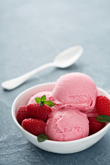Raspberry ice cream in white bowl