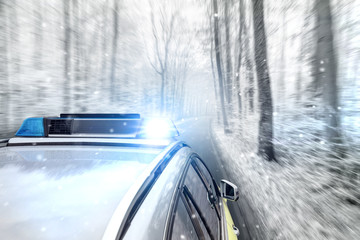 Polizeiauto bei Schneefall auf Landstraße