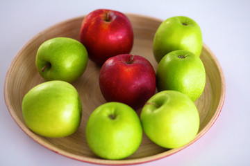 Still life arrangement of apples on a wooden platter