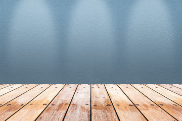 Empty wooden table with concrete wall background with light spot.