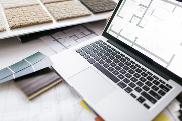 Detail of a laptop and paint samples on desk