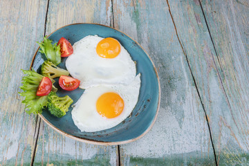 Two fried eggs and vegetables