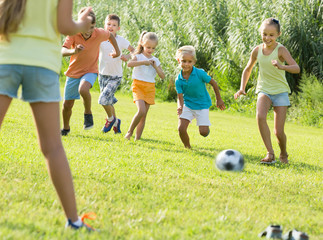 Obraz na płótnie Canvas children playing football on meadow .