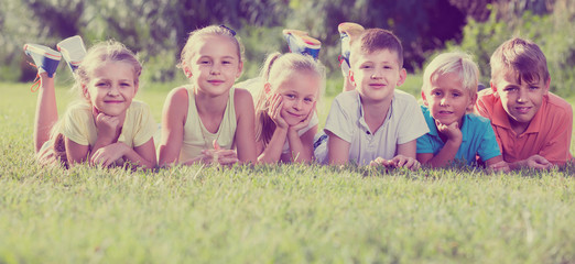 portrait of  children lying on grass in park and looking happy