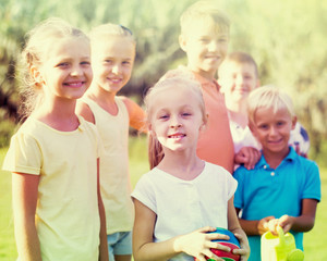 children standing outdoors on sunny day.