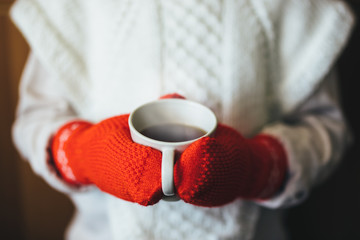 Cute blonde little girl holding hot steaming tea cup close up photo