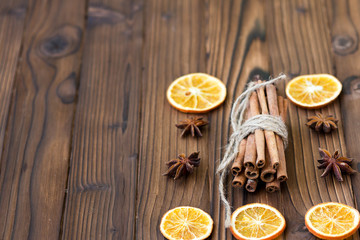 Cinnamon, dried oranges and anise on brown wooden table for cooking