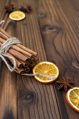 Cinnamon, dried oranges and anise on brown wooden table for cooking