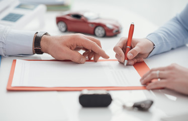 Driver signing a car insurance