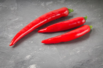 Fresh red cilli peppers isolated on gray background.