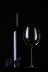 black red wine bottle with empty tall glass