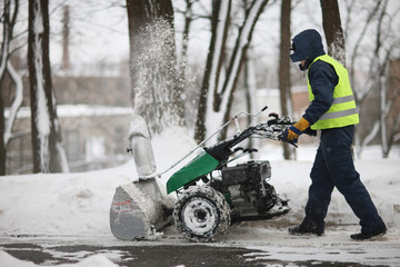 A man cleans the track park snow machines