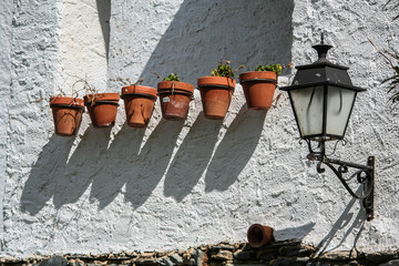 Pared de cal con macetas y farol