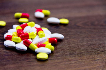 Colorful pills isolated on wooden background