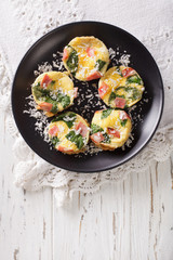 Tasty breakfast: frittata with spinach, ham and cheese close-up. vertical view from above