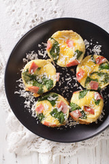 frittata with spinach, ham and cheese on a plate close-up on the table. vertical top view