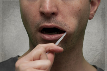 Mann gibt zur Untersuchen eine Speichelprobe ab