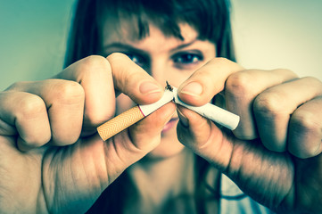 Woman holding a broken cigarette - stop smoking concept