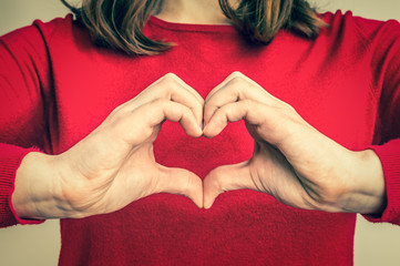 Female hands showing sign of heart - retro style