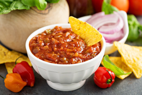 Red tomato spicy salsa with chips