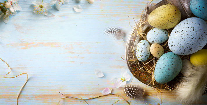 Easter background with Easter eggs and spring flowers. Top view with copy space