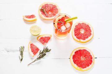Refreshing homemade grapefruit and rosemary cocktail on white wooden table