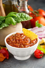Red tomato spicy salsa with chips