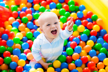 Fototapeta na wymiar Child playing in ball pit on indoor playground