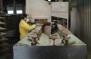 man that works in the factory of pottery