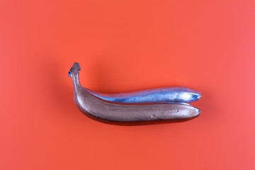 colored banana, orange abstract background, bronze, silver banana