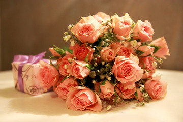 Bouquet of pink roses and a gift