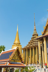 Fototapeta premium Prasat Phra Thep Bidon and Golden Stupa with tourists at Temple of the Emerald Buddha (Wat Phra Kaew), Grand Palace complex, Bangkok, Thailand