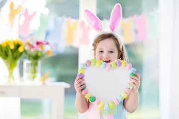 Obraz na płótnie Canvas Little girl in bunny ears on Easter egg hunt