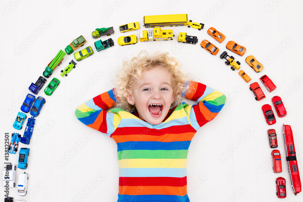 Wall mural little boy playing with toy cars. toys for kids.