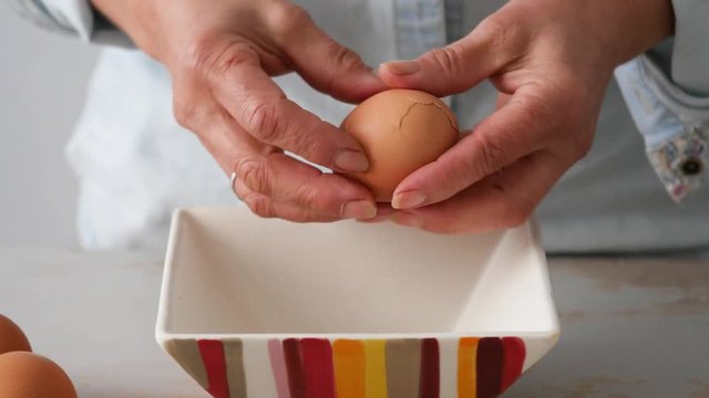 close up of hands of woman shells a hard-boiled egg