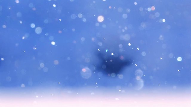 Abstract blue winter bokeh background, wintertime holidays snow backdrop with snowflakes out of focus