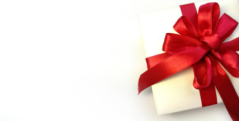 Gift box is white with a red bow 