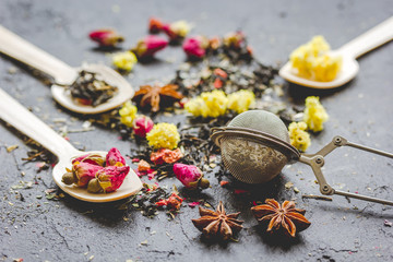 Tea herbs and spoons on grey background