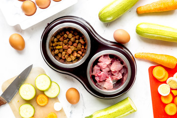 petfood set with vegetables and meat on kitchen table background top view