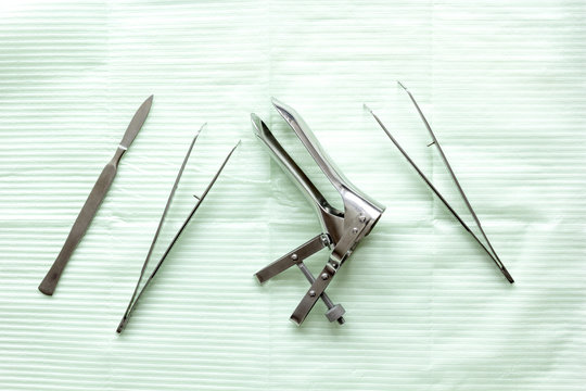 instruments of gynecologist on green background top view