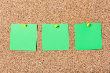 Three green notes pined in a row to cork board. Empty reminder cards.