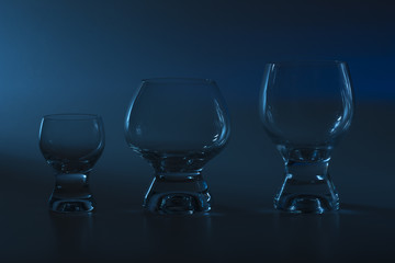 Glasses of different capacities for different grades of alcohol in blue light