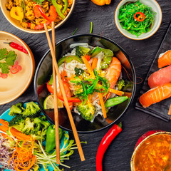 Asian food served on black stone, top view