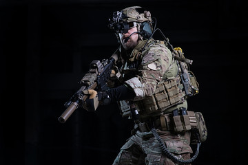 Spec ops soldier with gun/SWAT officer with rifle in hands, in helmet with night vision devices and...