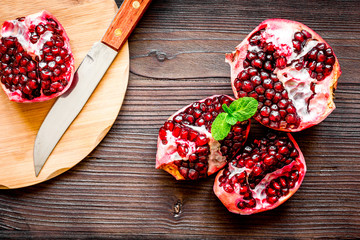 sliced pomegranate on wooden background top view